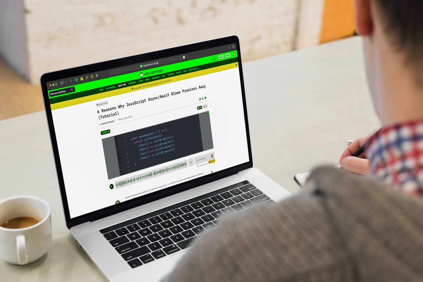 Person arbeitet an einem Laptop mit einer Kaffeetasse.
