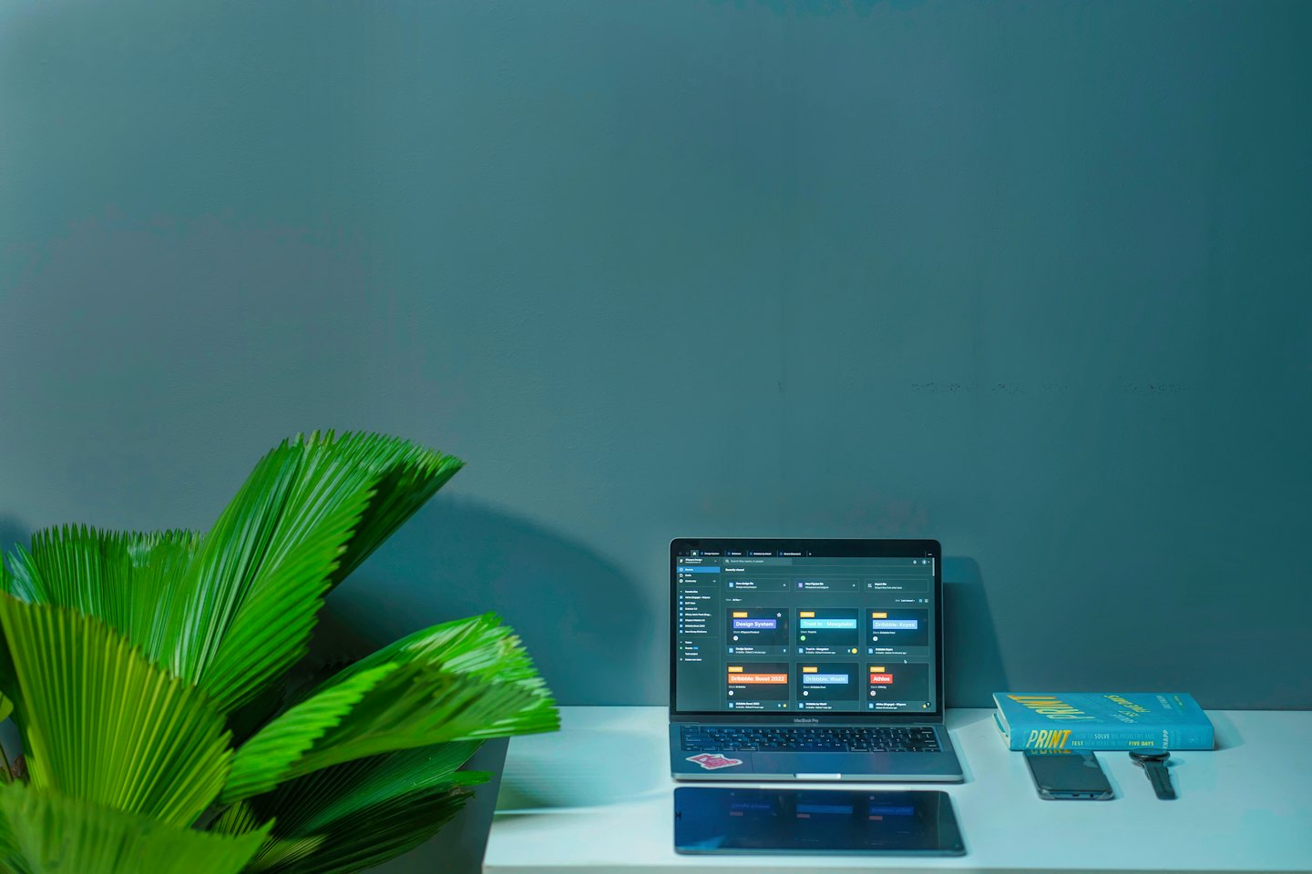 Laptop mit Projektmanagement-Software auf einem sauberen Schreibtisch mit einer Pflanze.
